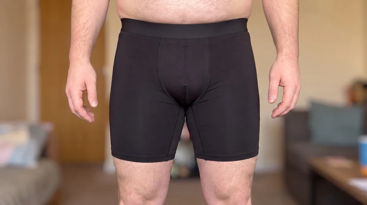 Zwarte boxer met lange pijpen gedragen door een model, van voren gezien.